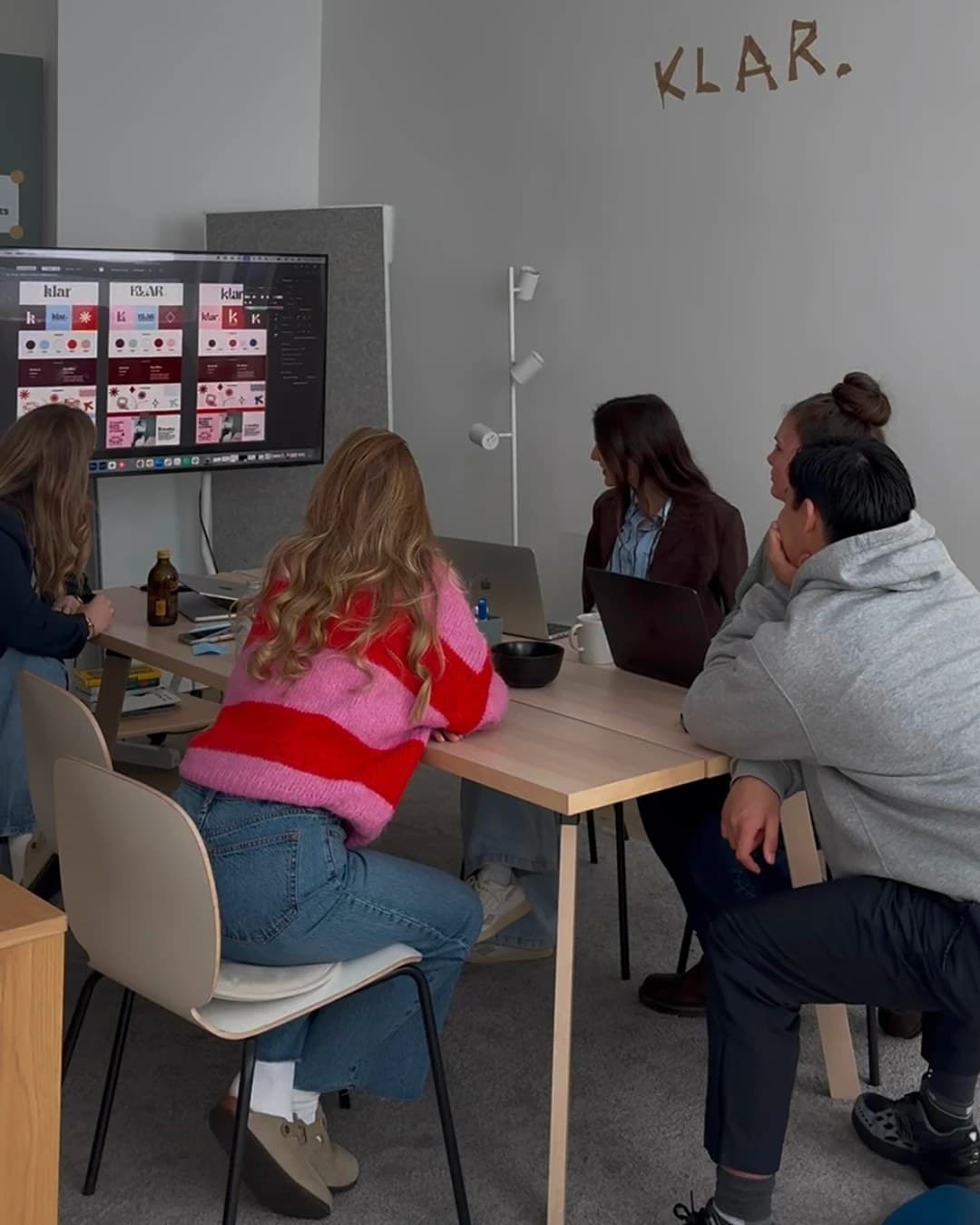 Team-Meeting am großen Tisch mit Präsentation auf dem Screen